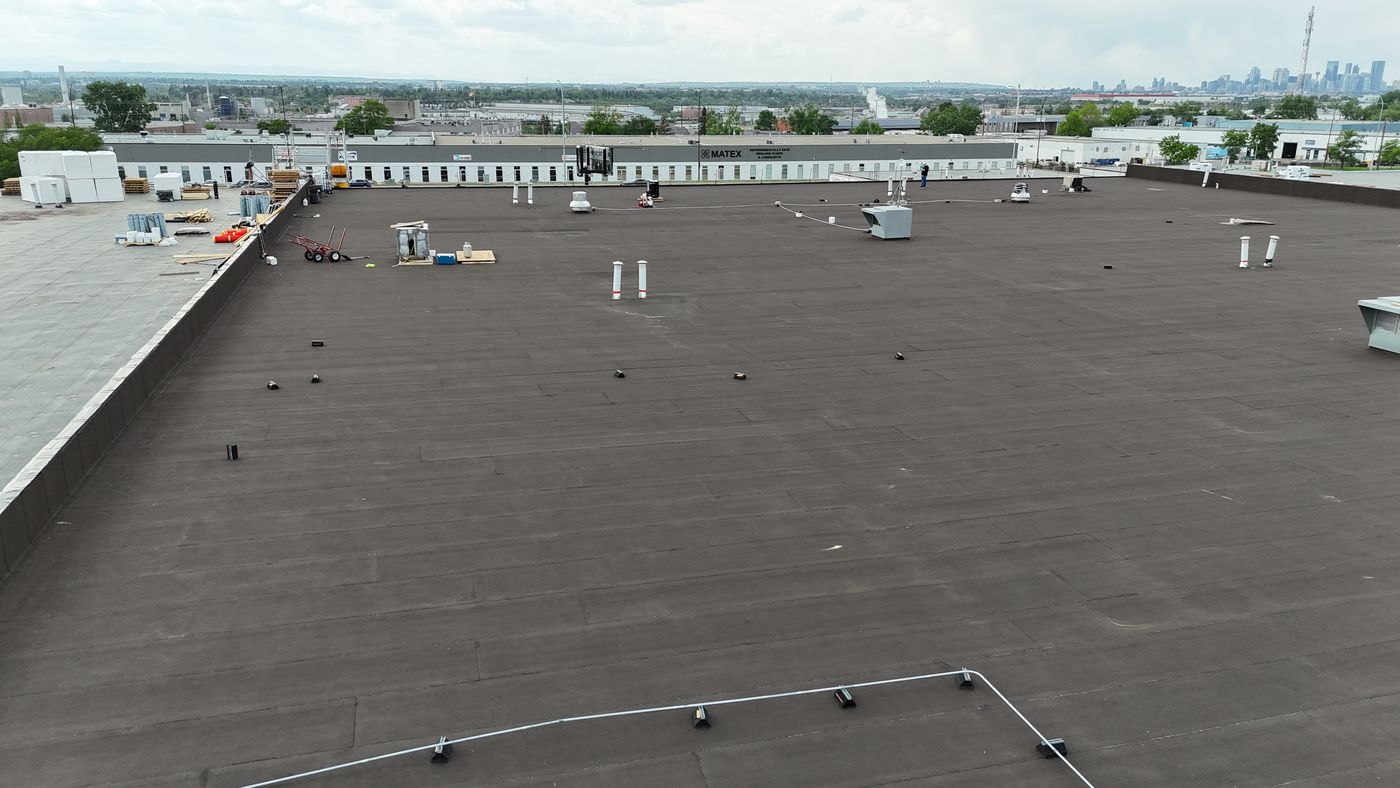 Finished commercial flat roof by City Roofing with the Calgary skyline in the distance