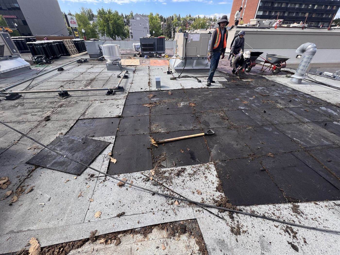 City Roofing crew tearing off an old commercial flat roof before replacement