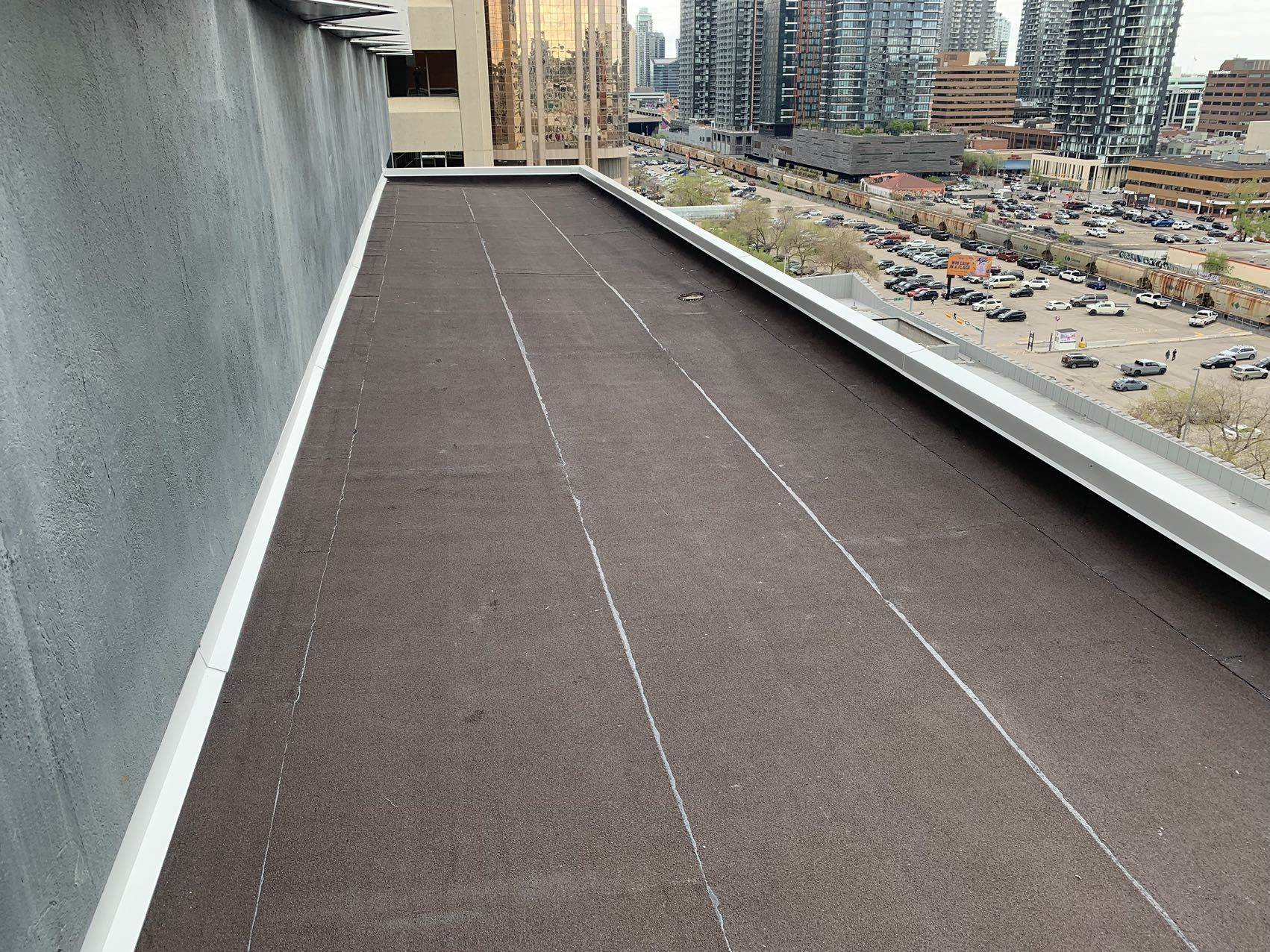 Commercial flat roof edge overlooking downtown Calgary during an inspection