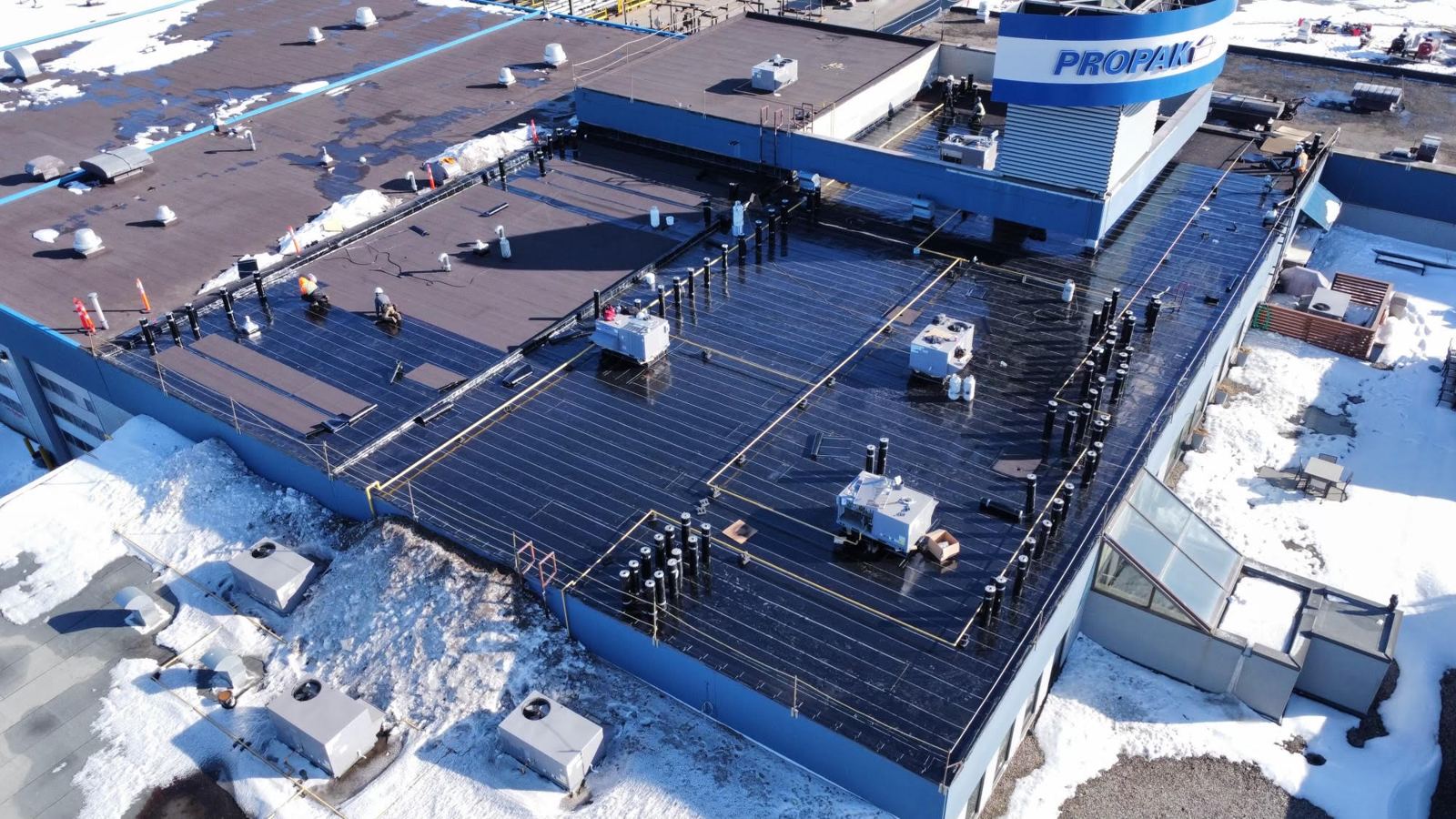 Crew working on a commercial flat roof in winter