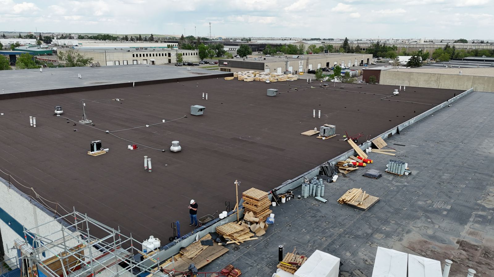 Crew finishing a large warehouse flat roof