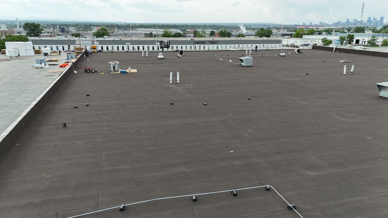 Finished flat roof on a Calgary warehouse with downtown in the distance