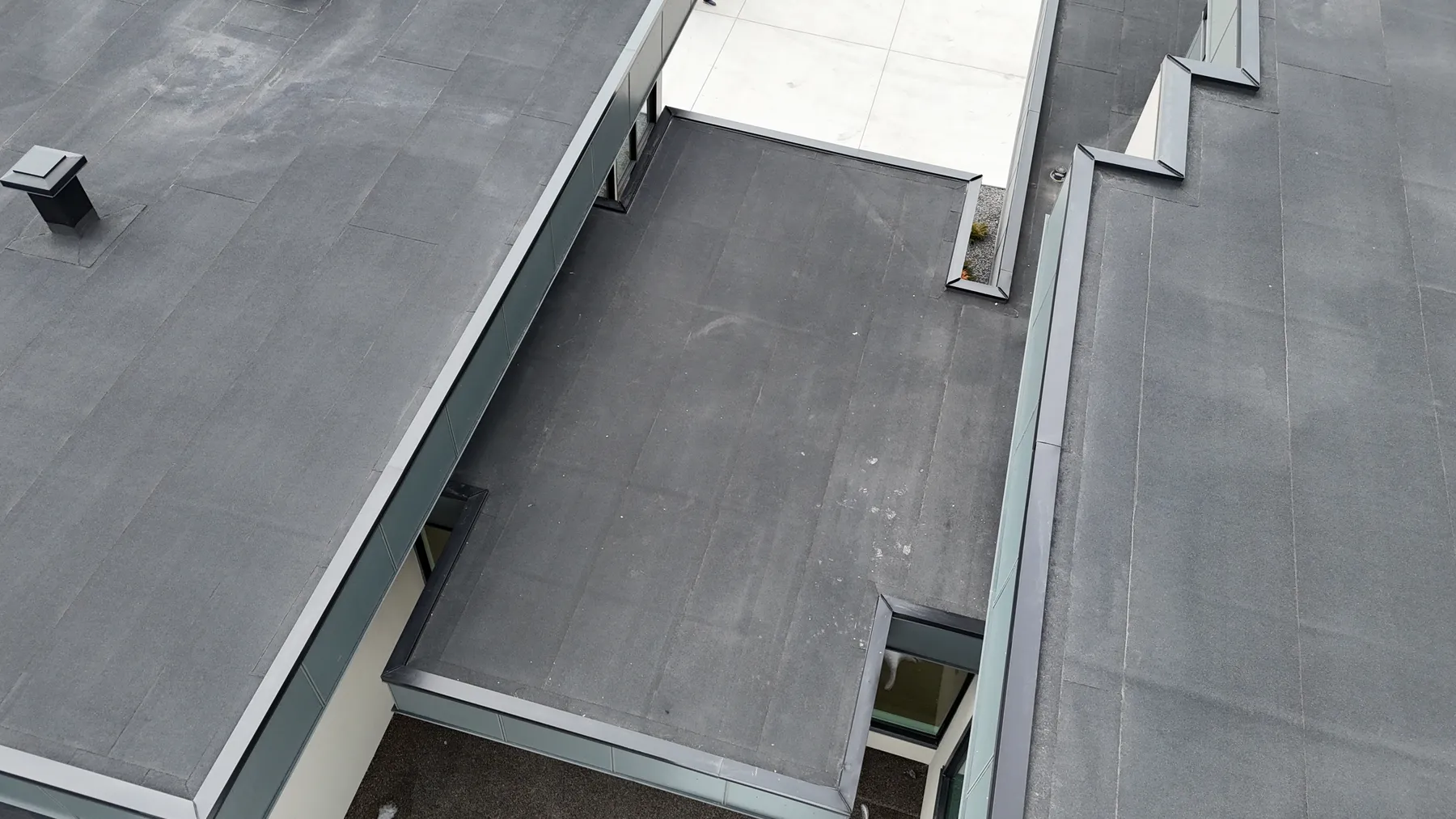 New flat roof running up to the wall of a house