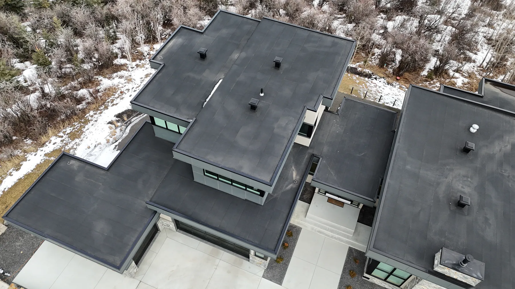 Aerial view of a modern home with flat roofs stepping down over several levels