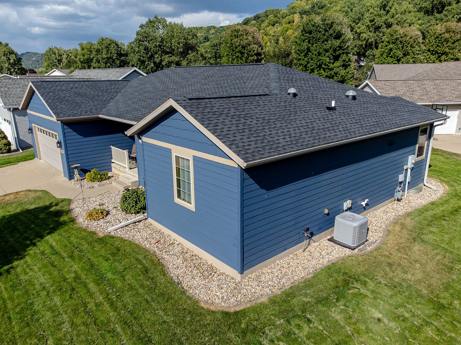House with blue fibre cement siding and a dark shingle roof