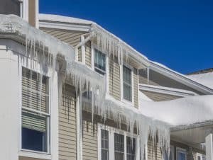 Ice dams and snow on roof and gutters after bitter cold in New England, USA