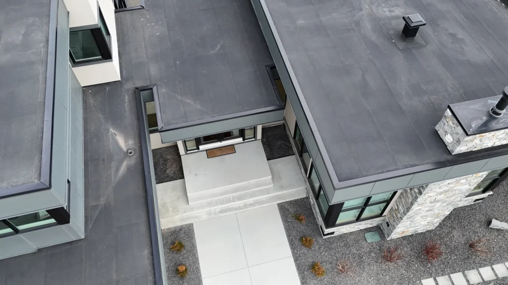 Aerial view of a modern house with a new low-slope roof above the front entrance