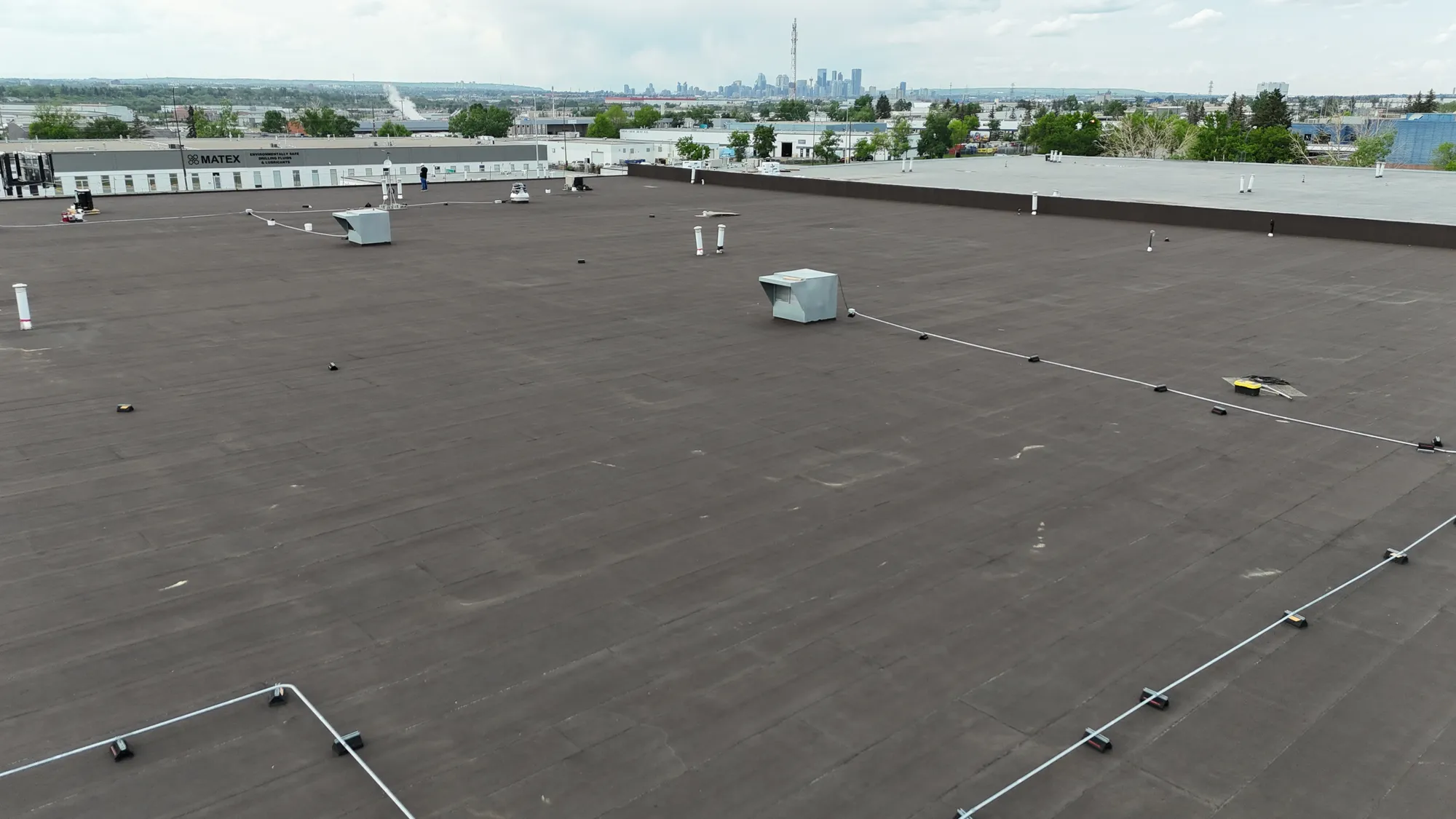 New roof on a large building with the Calgary skyline in the distance