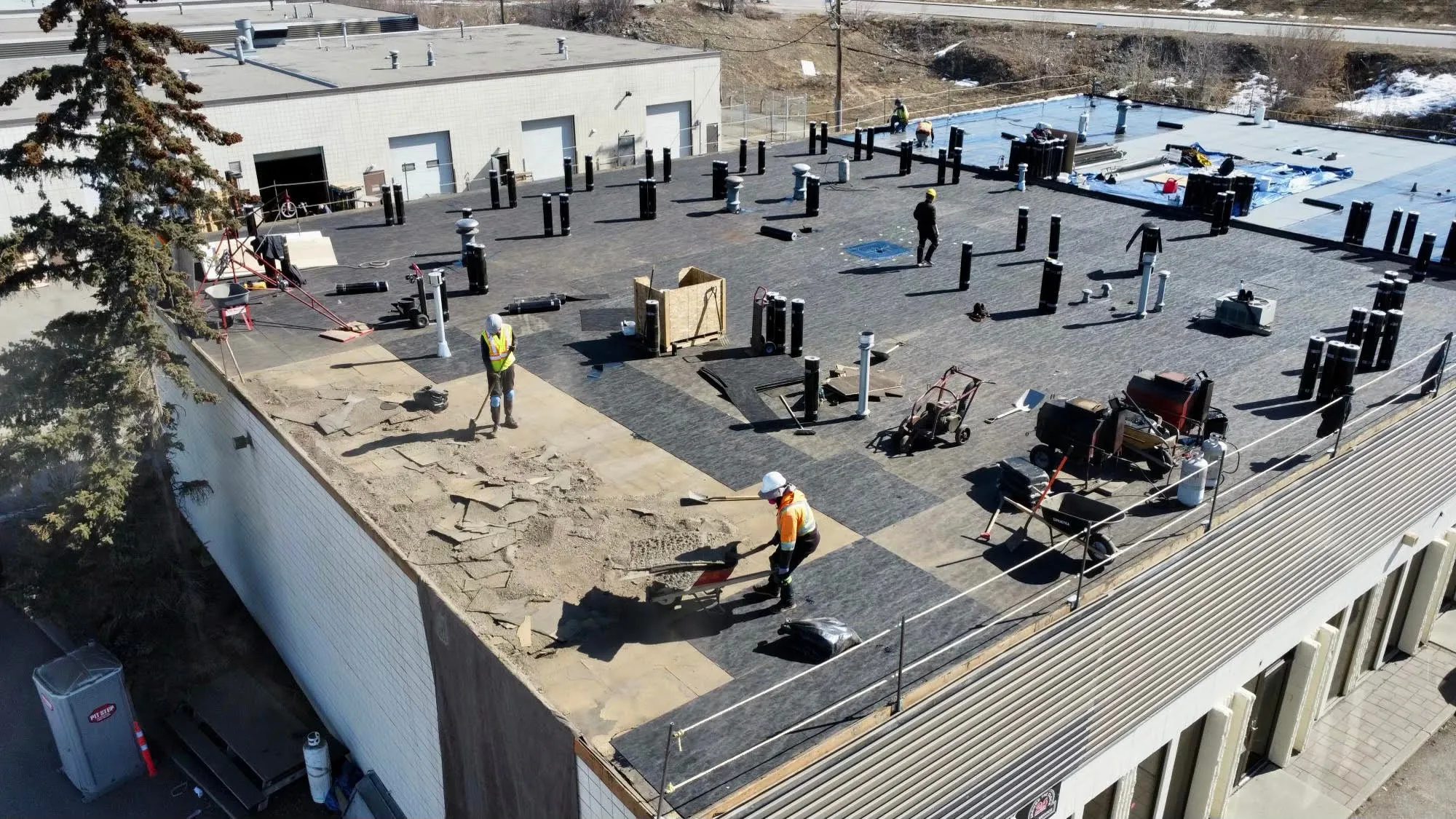 Aerial view of a roofing crew working on a roof during a tear-off