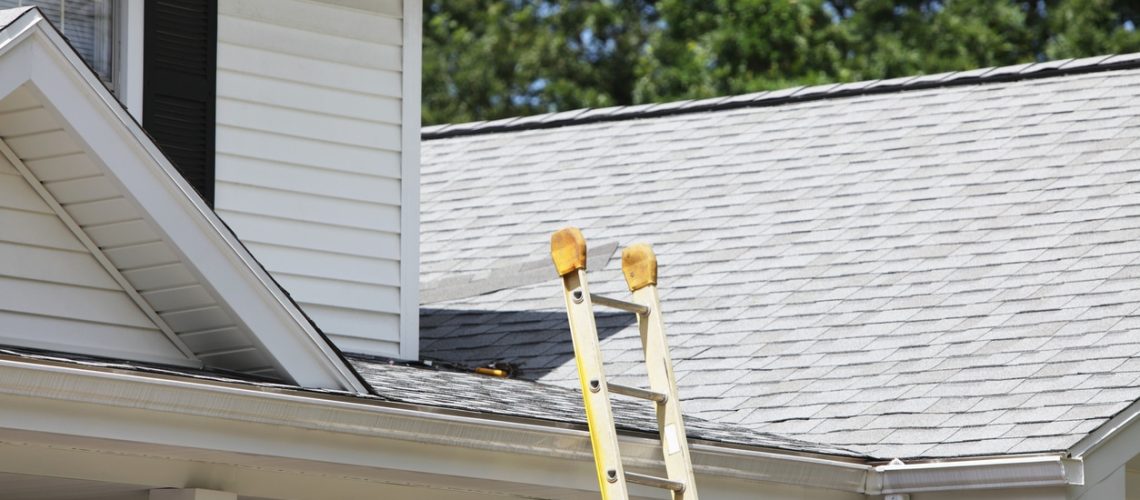 Ladder Leaning Against House Roof Gutter