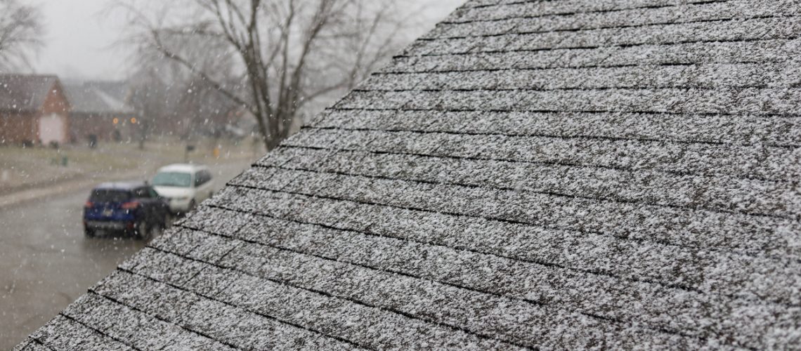 Snow on shingles on a roof of a residential home